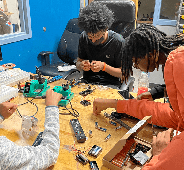 Students do hands on robotics building work during the 2022 STEM Maker Camp.